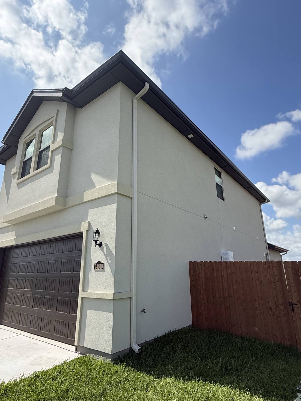 Seamless aluminum gutter and downspout running down the corner of a Rio Grande Valley home
